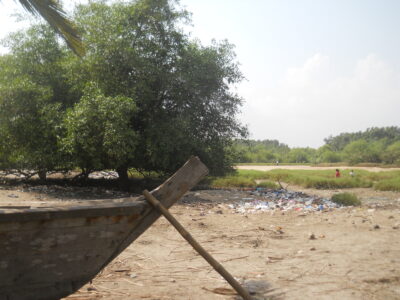 Lagoon shore with trash and fishing boat